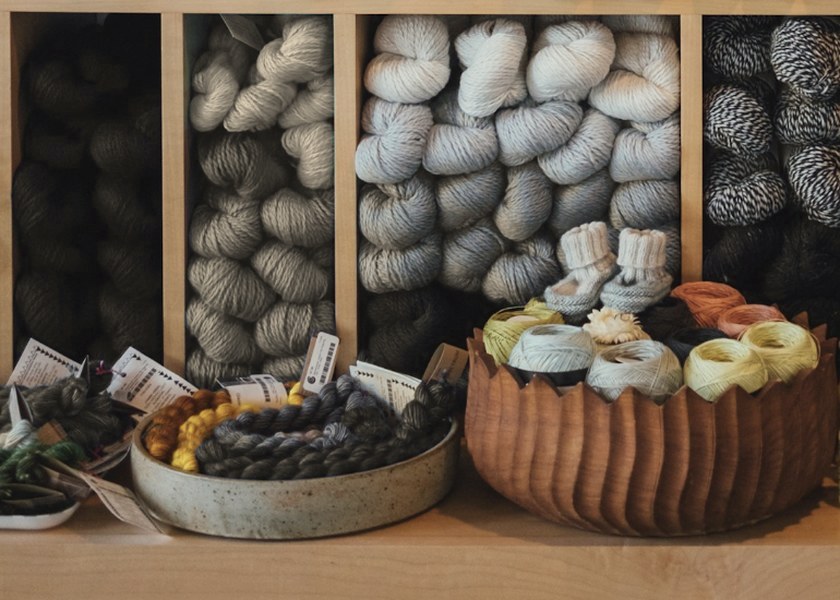 Wooden craft shelf with yarn, thread and small kits in natural light