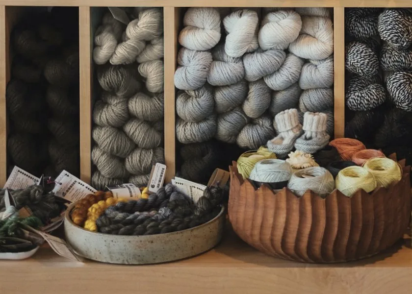Wooden craft shelf with yarn, thread and small kits in natural light